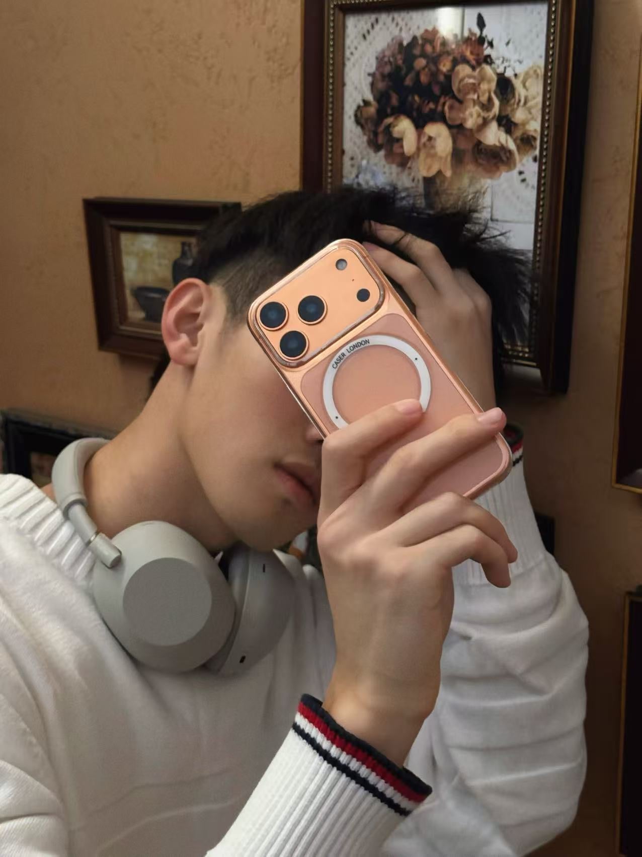 CASER LONDON the iconic case with umbrella icon hold by model on orange iPhone 17 pro