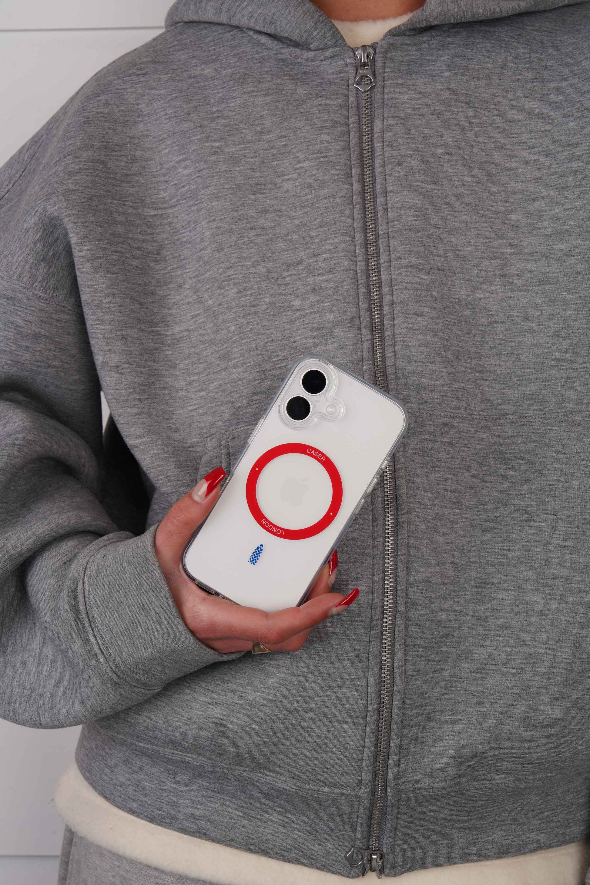 Person holding a iPhone 16 case with Red MagSafe Ring and Gherkin icon