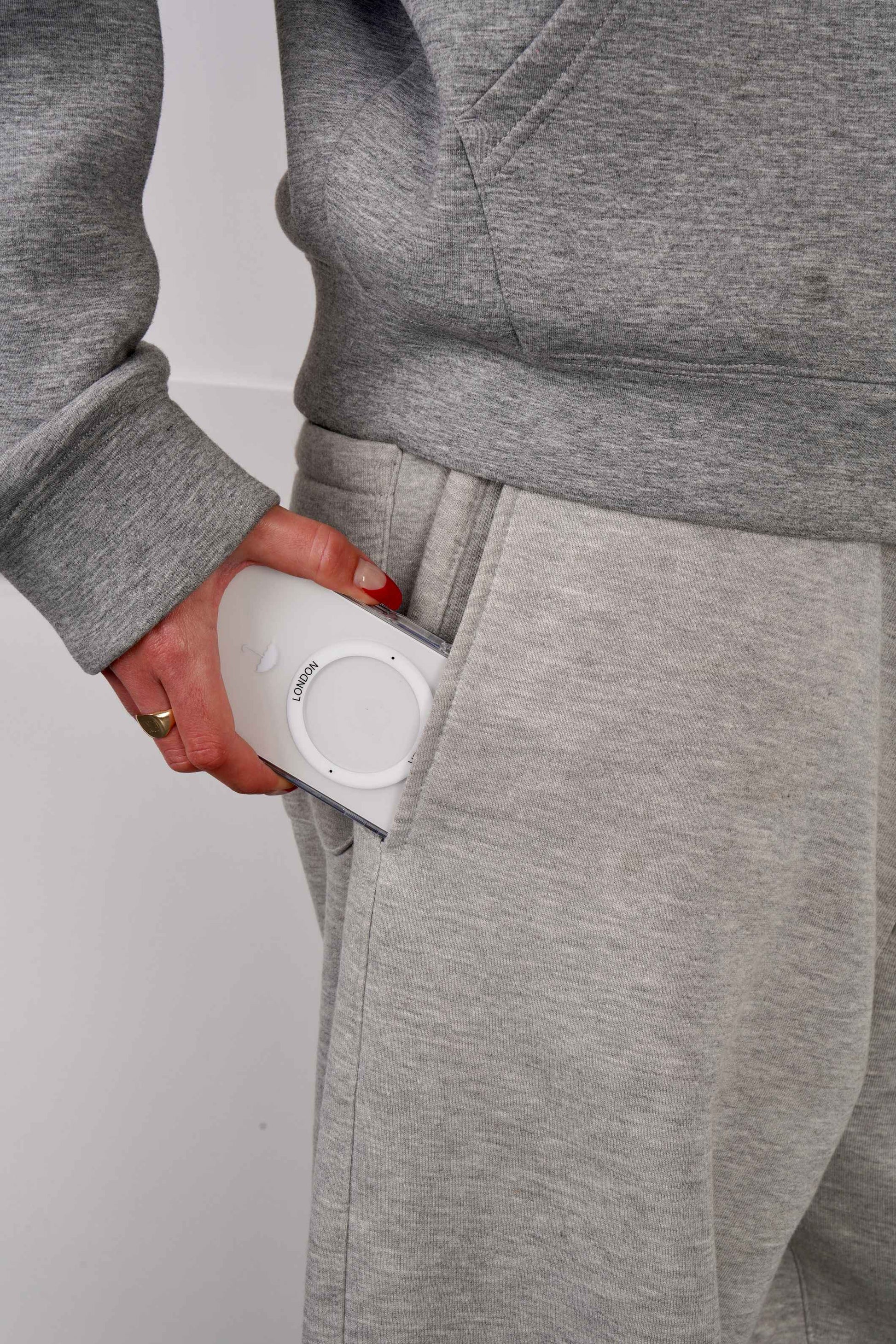 Person holding a iPhone 16 case with White MagSafe Ring and Umbrella icon